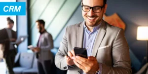 Handsome businessman checking emails on the phone in modern office